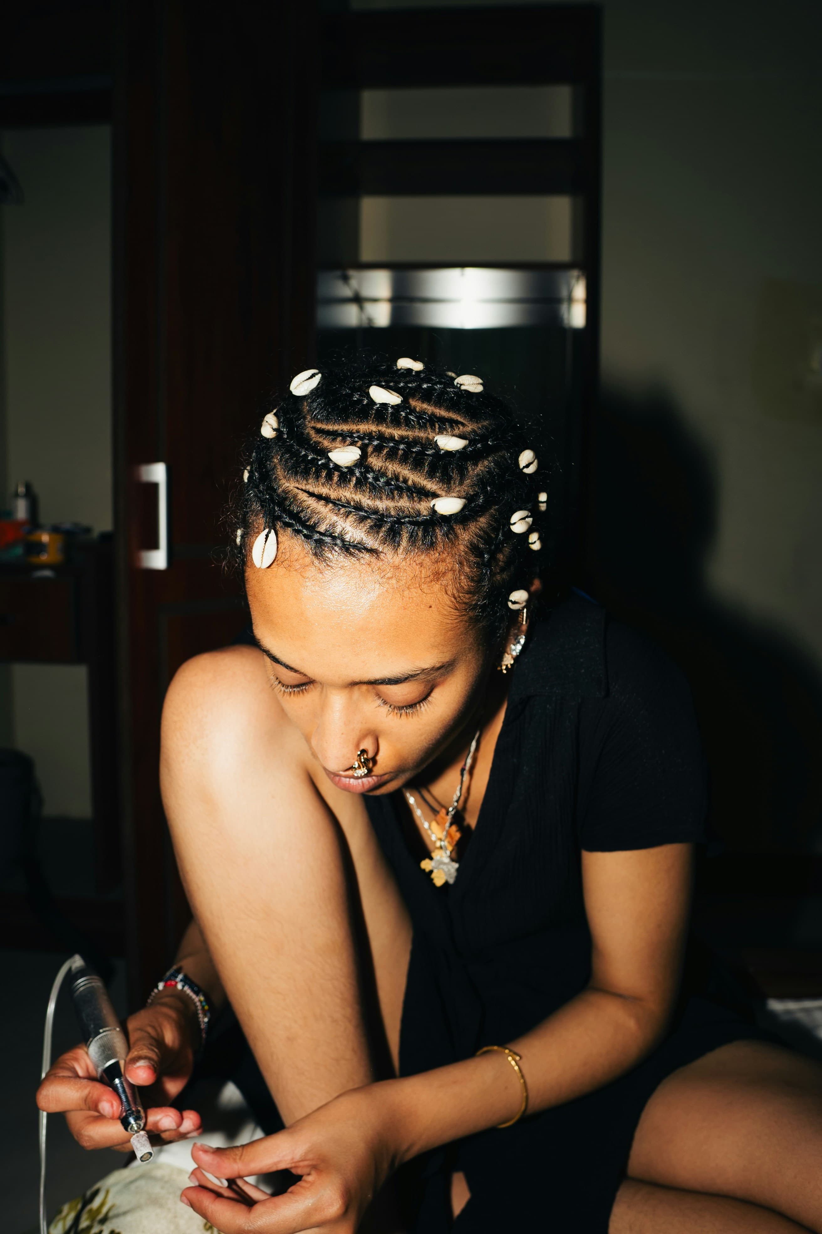 Femme avec des cornrows ornees de coquillages